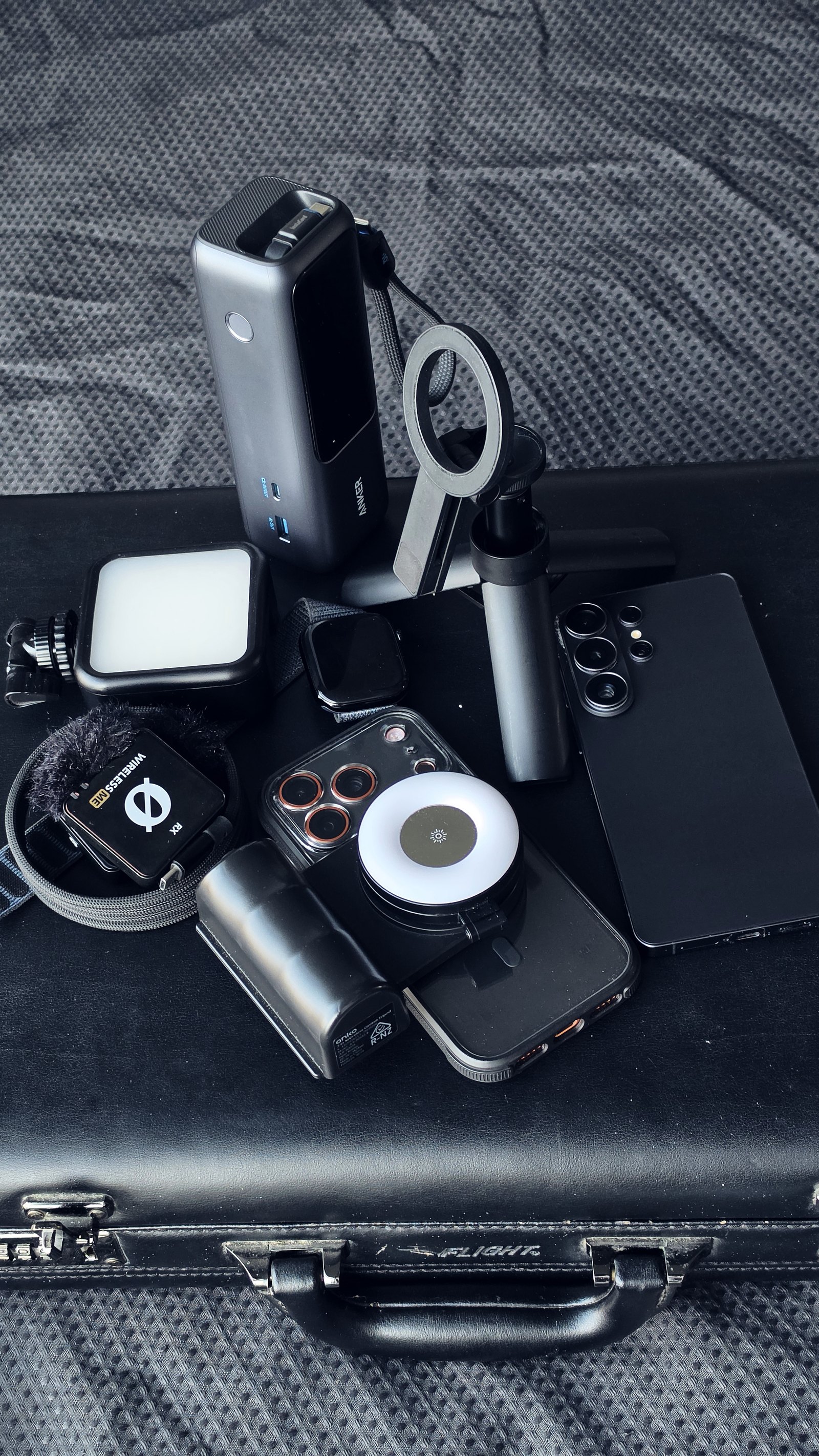 The full filming kit laid out on its case, including phones, lights, microphone and grips