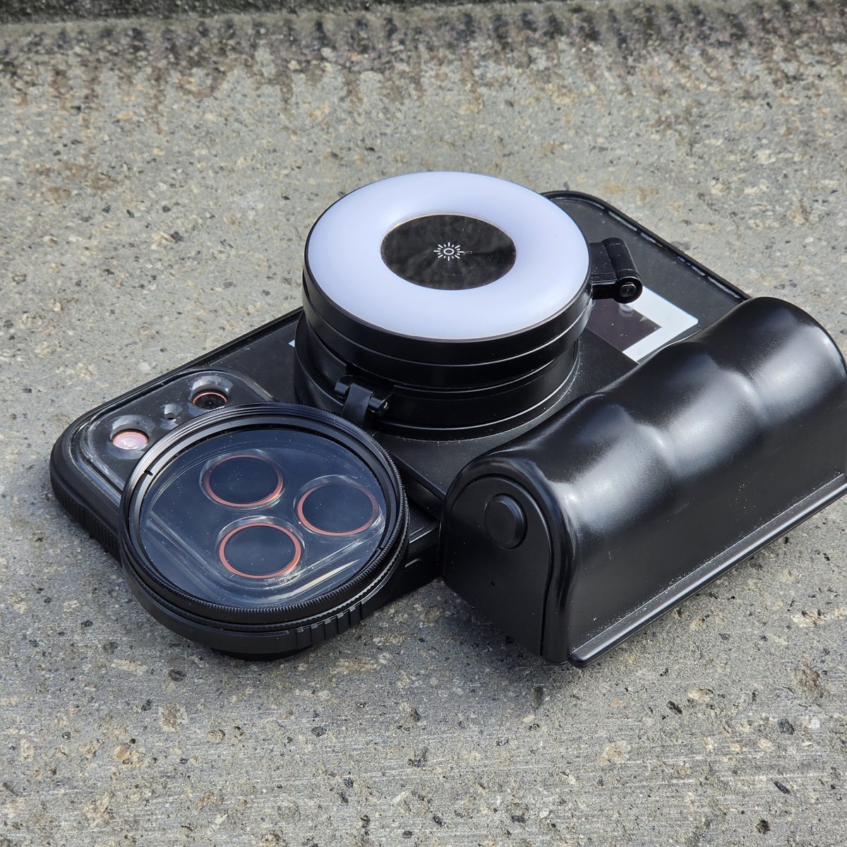 The rig assembled: iPhone in its cage with the ring light, lens filter and battery grip